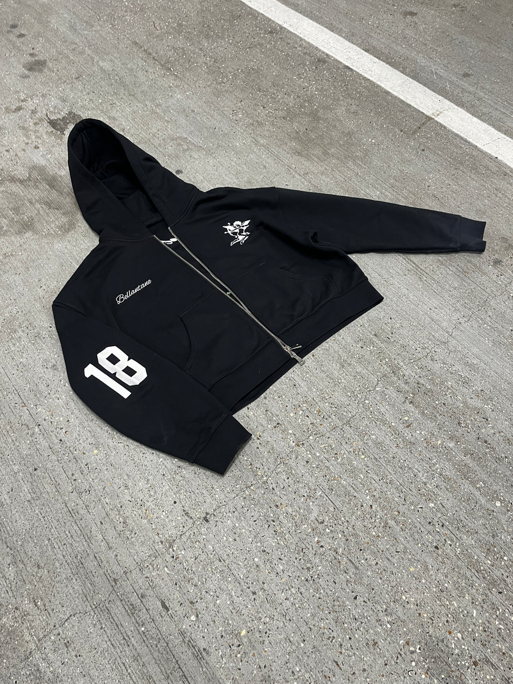 Black jacket with a logo on a concrete surface