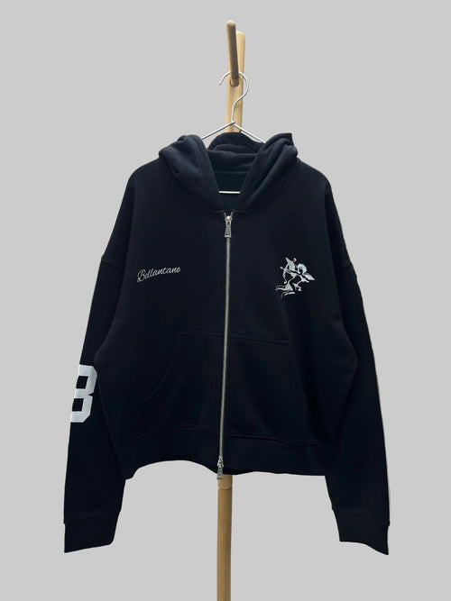 Black hoodie with white branding on a hanger in a store setting