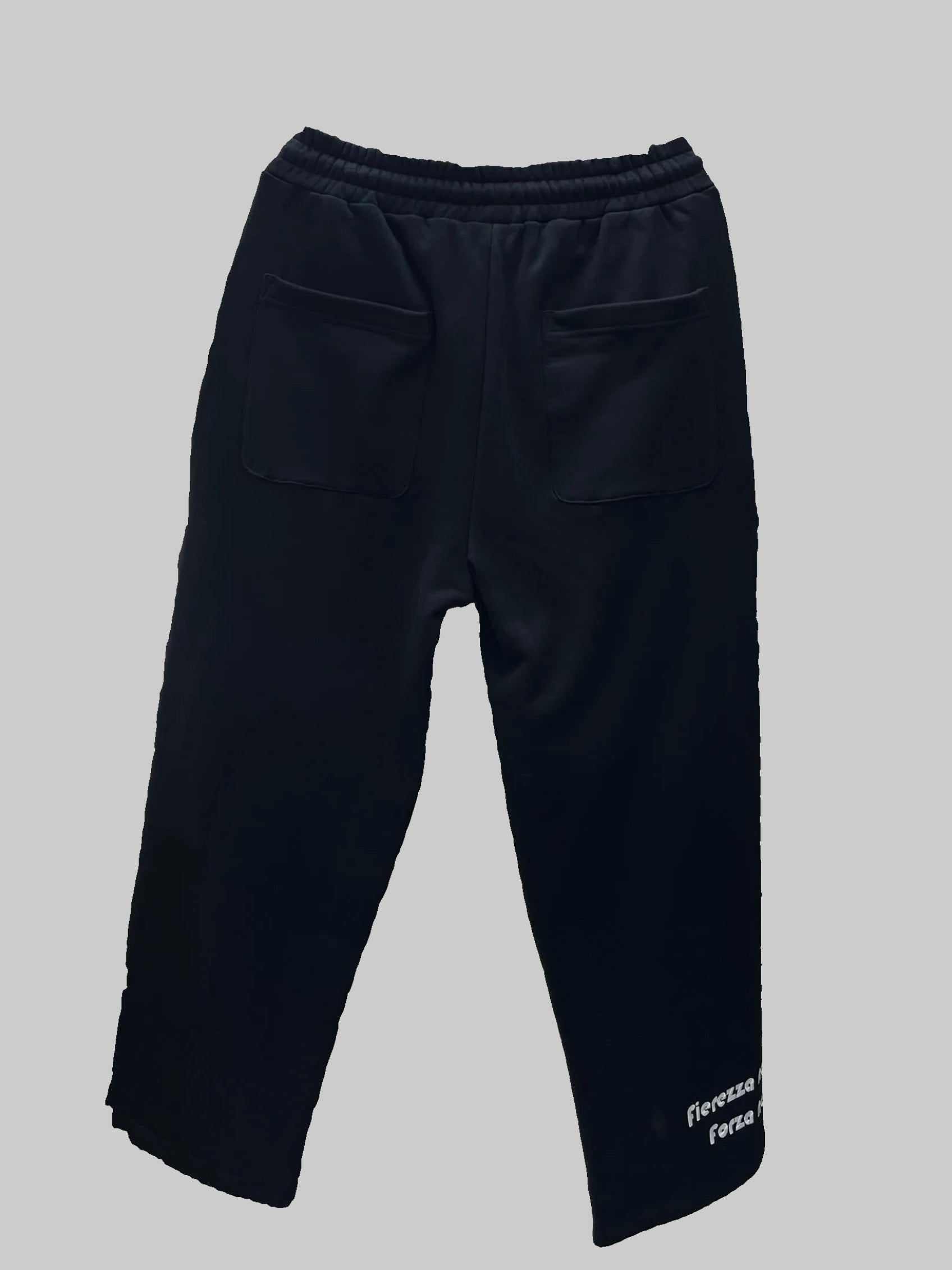 Black pants on a hanger in an indoor setting with furniture and decor.